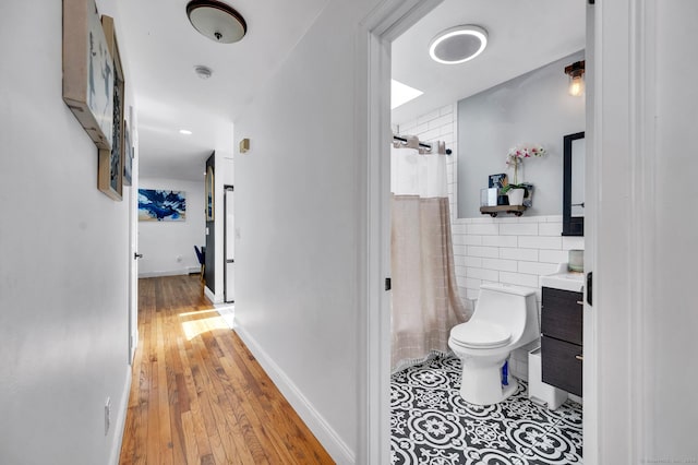 full bathroom with hardwood / wood-style floors, vanity, toilet, and shower / bathtub combination with curtain