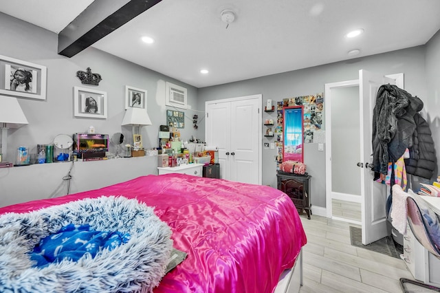 bedroom featuring beam ceiling and a closet