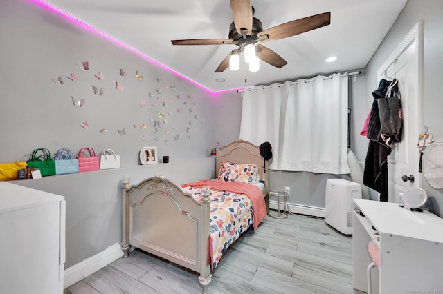 bedroom featuring ceiling fan and a baseboard heating unit