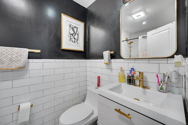 bathroom with a shower with shower curtain, vanity, toilet, and tile walls