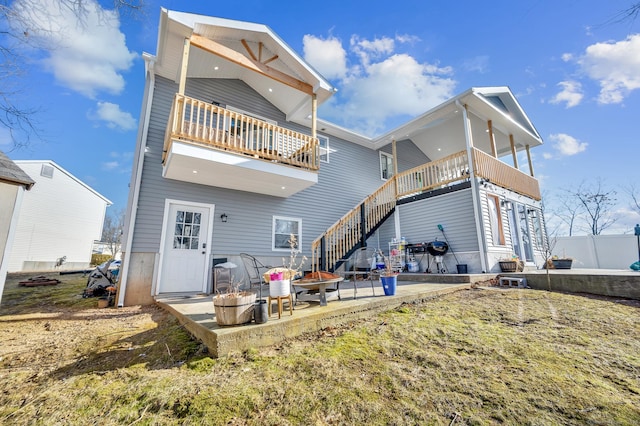 rear view of house featuring a patio and a balcony