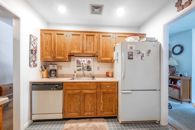 kitchen with white refrigerator, dishwasher, and sink