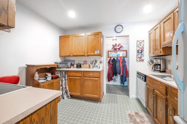 kitchen featuring stainless steel dishwasher, sink, and white fridge