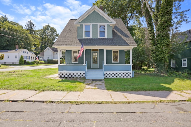 view of front of property featuring covered porch and a front lawn