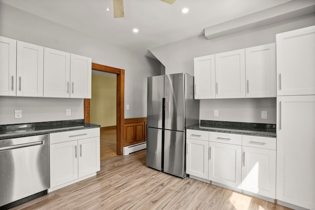 kitchen featuring appliances with stainless steel finishes, a baseboard heating unit, and white cabinetry