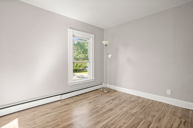 empty room with a baseboard radiator and light wood-type flooring