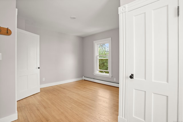 unfurnished bedroom with light hardwood / wood-style floors and baseboard heating