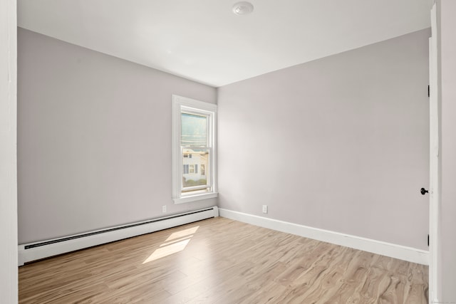 empty room with a baseboard radiator and light wood-type flooring