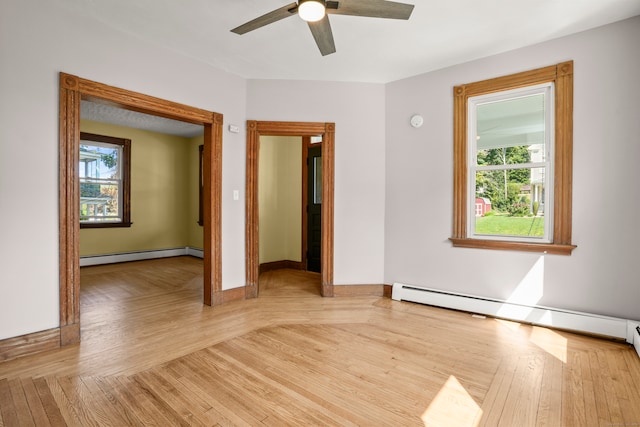 spare room with a wealth of natural light, light wood-type flooring, and baseboard heating