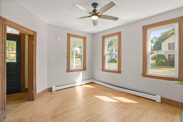 spare room with a healthy amount of sunlight, a baseboard radiator, and ceiling fan