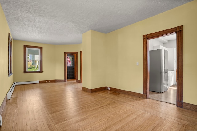 empty room with a textured ceiling and light wood-type flooring