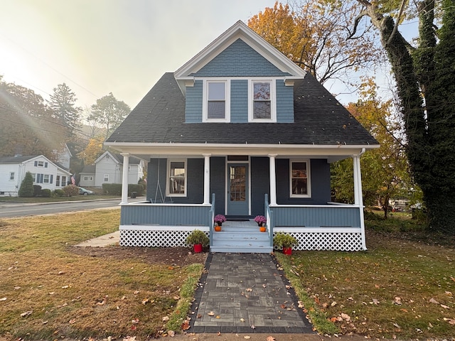 bungalow featuring a porch and a front lawn