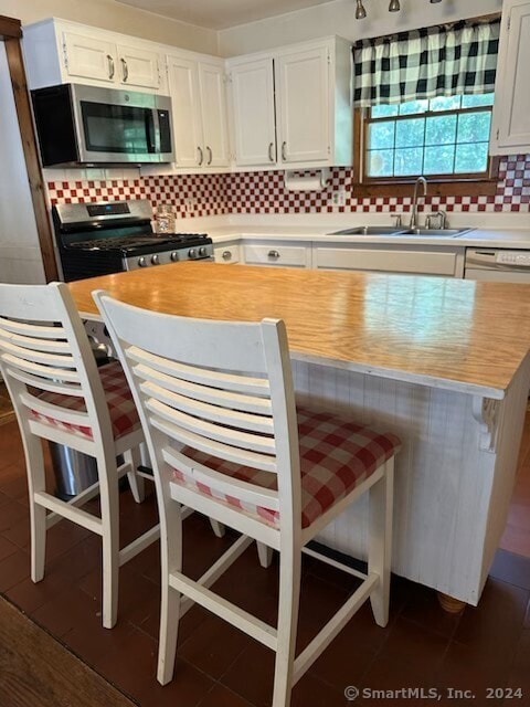 kitchen featuring sink, white cabinetry, backsplash, and appliances with stainless steel finishes