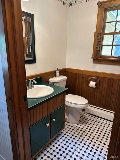 bathroom featuring tile patterned flooring, toilet, baseboard heating, and vanity