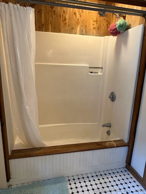 bathroom with shower / bath combo and tile patterned flooring