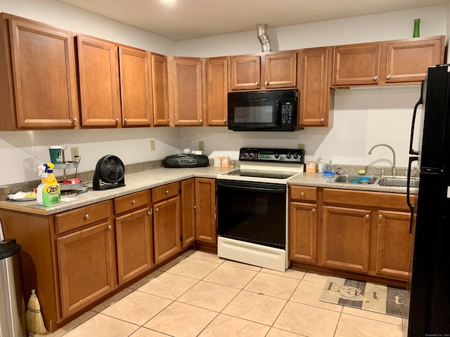 kitchen with sink, black appliances, and light tile patterned floors