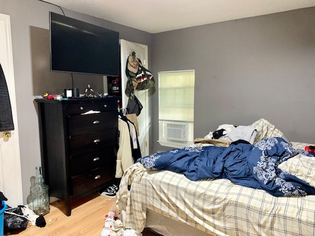 bedroom with light wood-type flooring and cooling unit