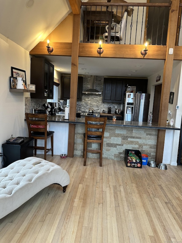 130 Valley Rd, North Branford, CT 06471 - kitchen featuring decorative backsplash, dark countertops, wall chimney exhaust hood, and light wood finished floors