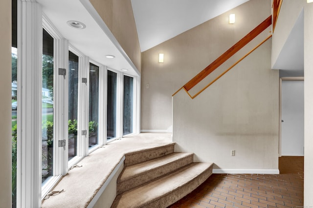 stairway featuring high vaulted ceiling