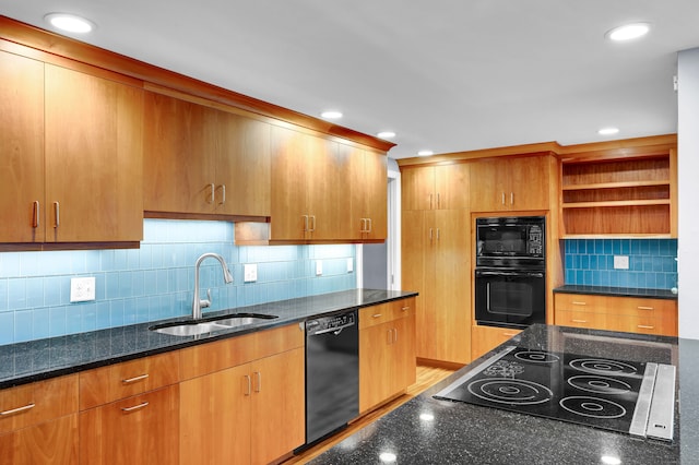 kitchen with dark stone counters, black appliances, backsplash, light wood-type flooring, and sink