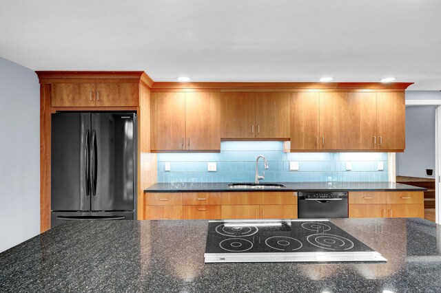 kitchen featuring black appliances, sink, dark stone counters, and decorative backsplash