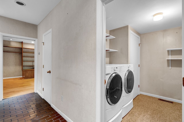 laundry area with separate washer and dryer and hardwood / wood-style floors