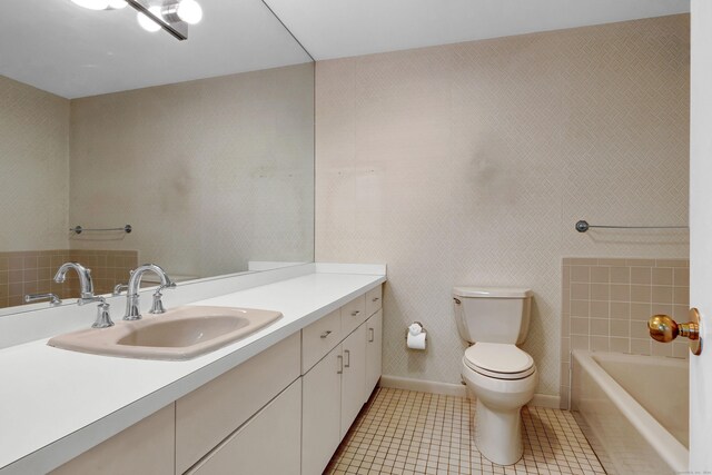 bathroom with vanity, a bath, tile patterned flooring, and toilet