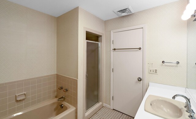 bathroom featuring shower with separate bathtub, sink, and tile patterned flooring