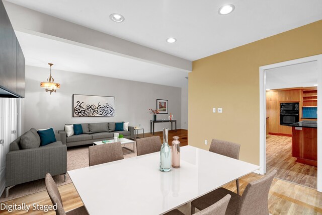 dining area with light hardwood / wood-style flooring and a chandelier