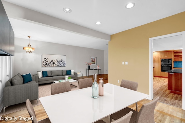 dining space featuring a notable chandelier and light wood-type flooring