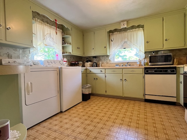 interior space with dishwasher, separate washer and dryer, a healthy amount of sunlight, and sink