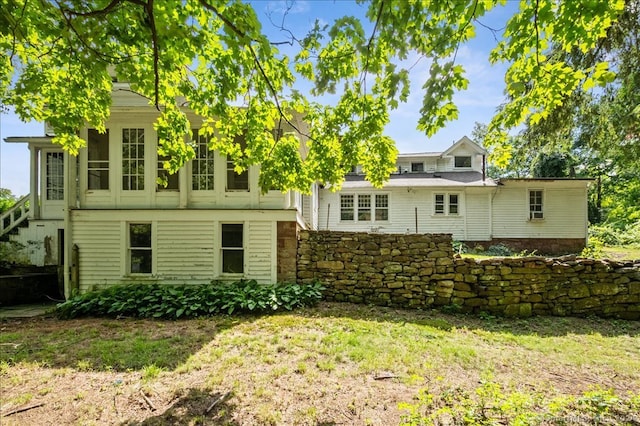 rear view of house featuring a lawn