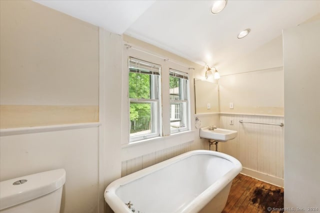 bathroom with sink, wood-type flooring, toilet, and a bathing tub