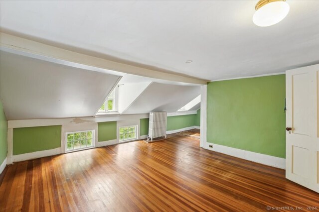 bonus room with lofted ceiling, wood-type flooring, and radiator