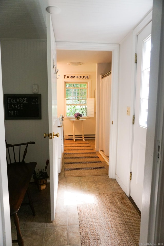 hallway with a baseboard radiator and tile patterned floors