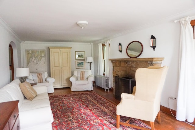 living room featuring radiator heating unit, ornamental molding, and wood-type flooring