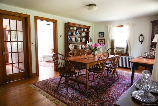 dining room with cooling unit, radiator, and hardwood / wood-style floors