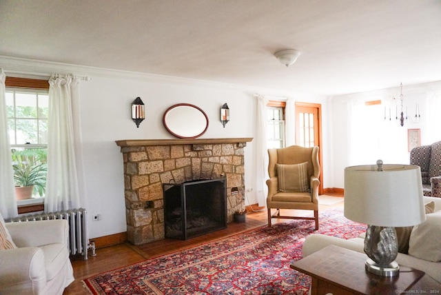 living room with an inviting chandelier, hardwood / wood-style flooring, radiator heating unit, and ornamental molding