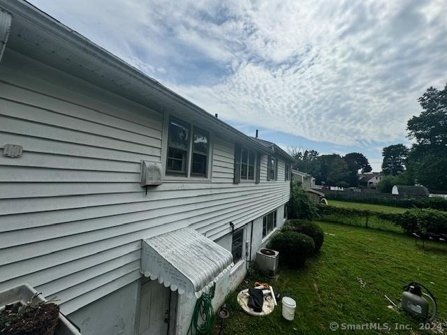 view of home's exterior featuring a yard and central AC