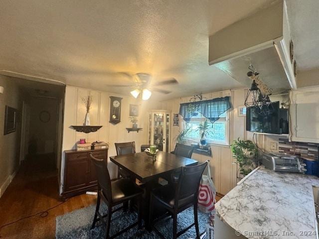 dining area featuring a toaster, a textured ceiling, a ceiling fan, and dark wood-style flooring