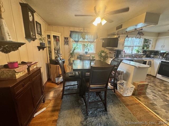 dining area with a ceiling fan, visible vents, dark wood-style flooring, and a textured ceiling