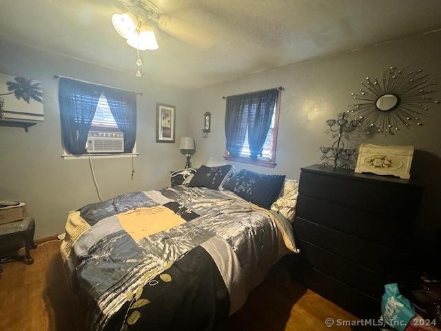 bedroom featuring cooling unit and wood finished floors