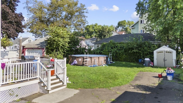 view of yard featuring a pool side deck and a storage shed