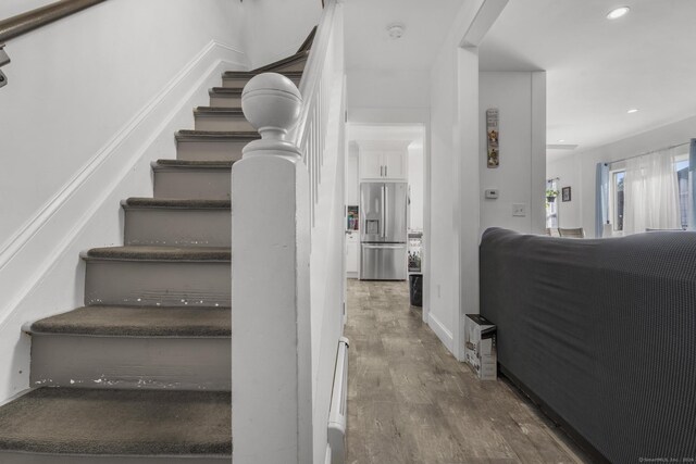 staircase featuring a baseboard radiator and hardwood / wood-style floors