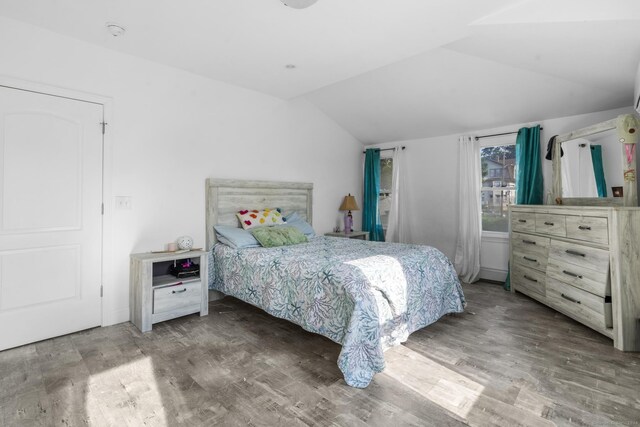 bedroom with hardwood / wood-style floors and vaulted ceiling