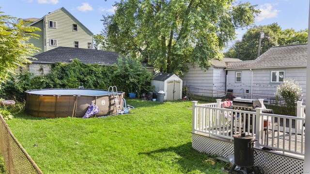 view of yard with a swimming pool side deck and a storage shed