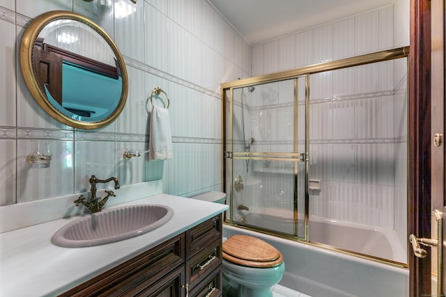 bathroom with toilet, backsplash, tile walls, enclosed tub / shower combo, and vanity