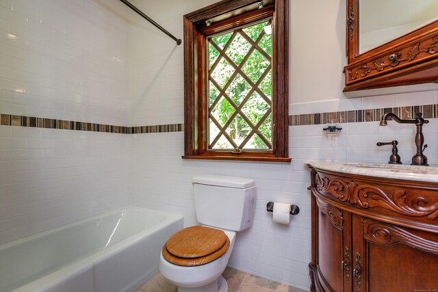 bathroom featuring vanity, tile walls, and toilet