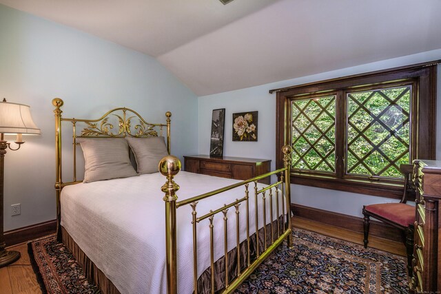 bedroom featuring lofted ceiling and hardwood / wood-style floors