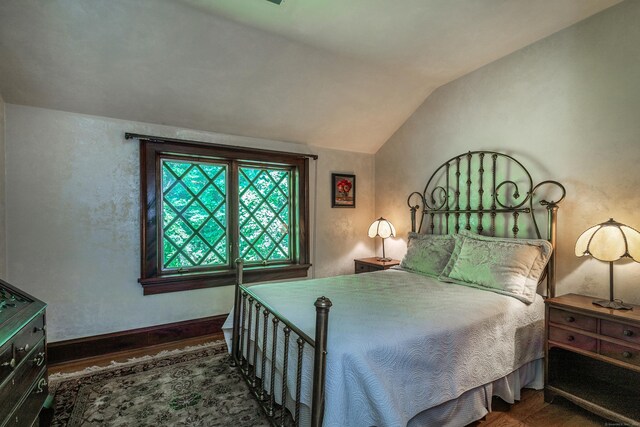 bedroom featuring vaulted ceiling and dark hardwood / wood-style floors